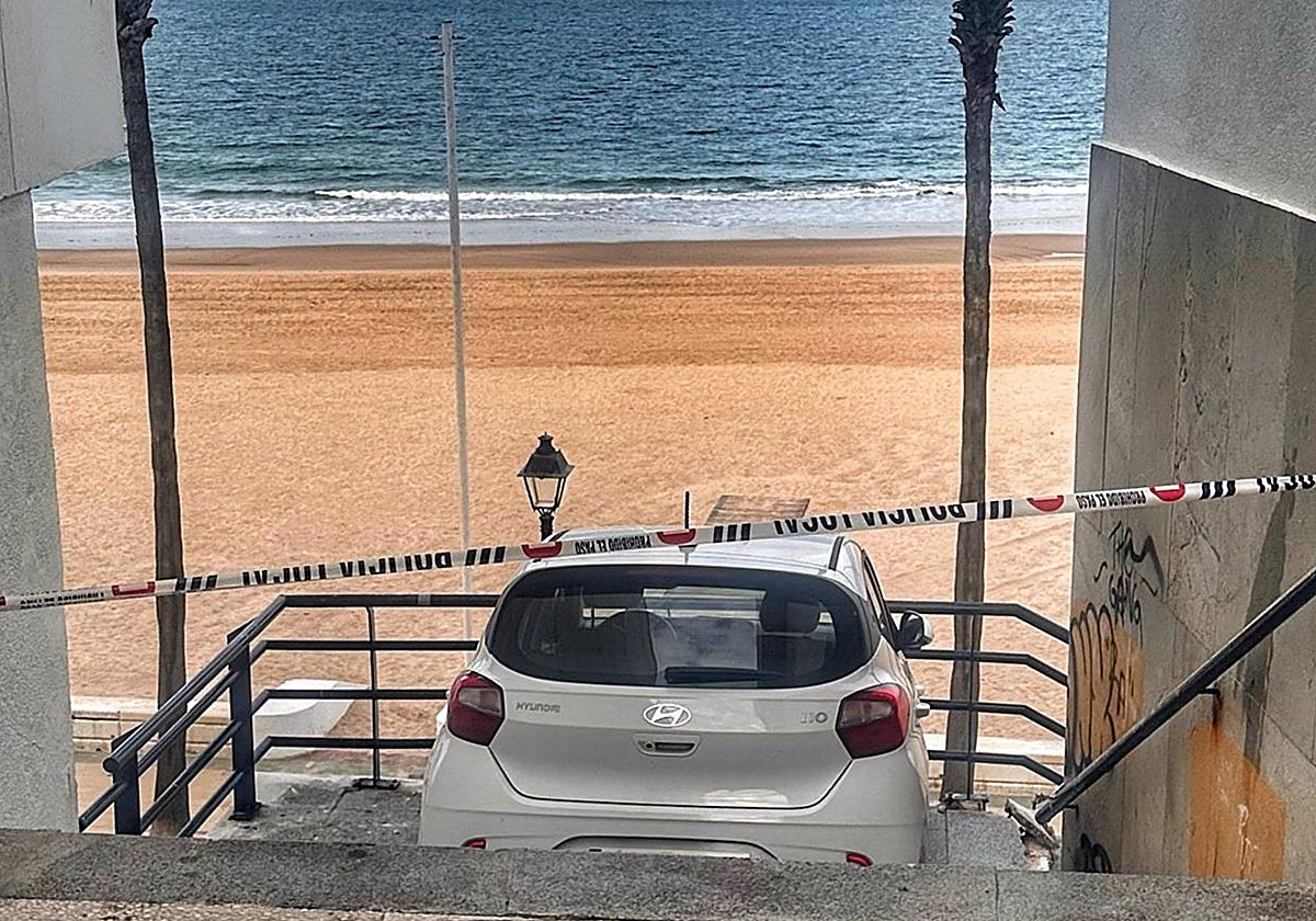 Un coche en unas escaleras de acceso a la playa en Rota (Málaga).