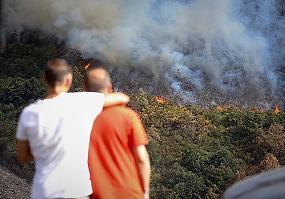 Varias personas observan el incendio, en la sierra de O Courel.