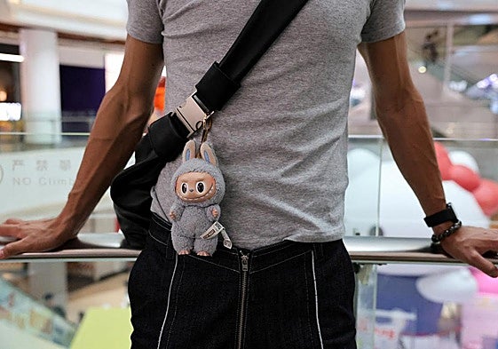 Una persona lleva una bolsa con una muñeca Labubu, en Shanghái, China.