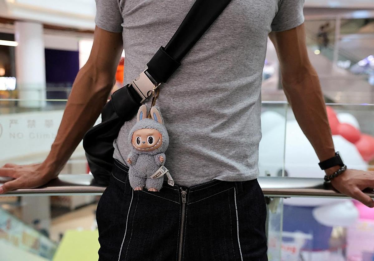 Una persona lleva una bolsa con una muñeca Labubu, en Shanghái, China.