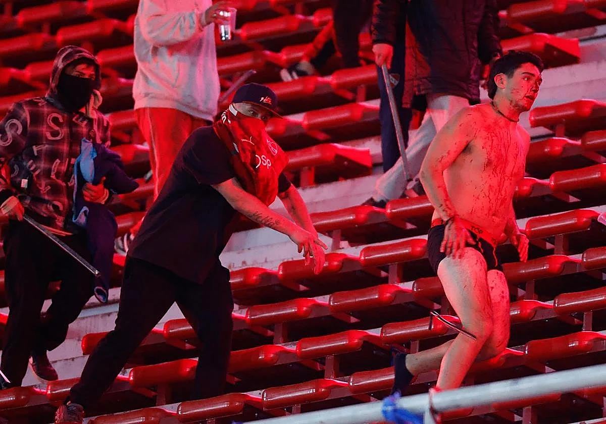 Hinchas se enfrentan durante el partido entre Independiente y Universidad de Chile.
