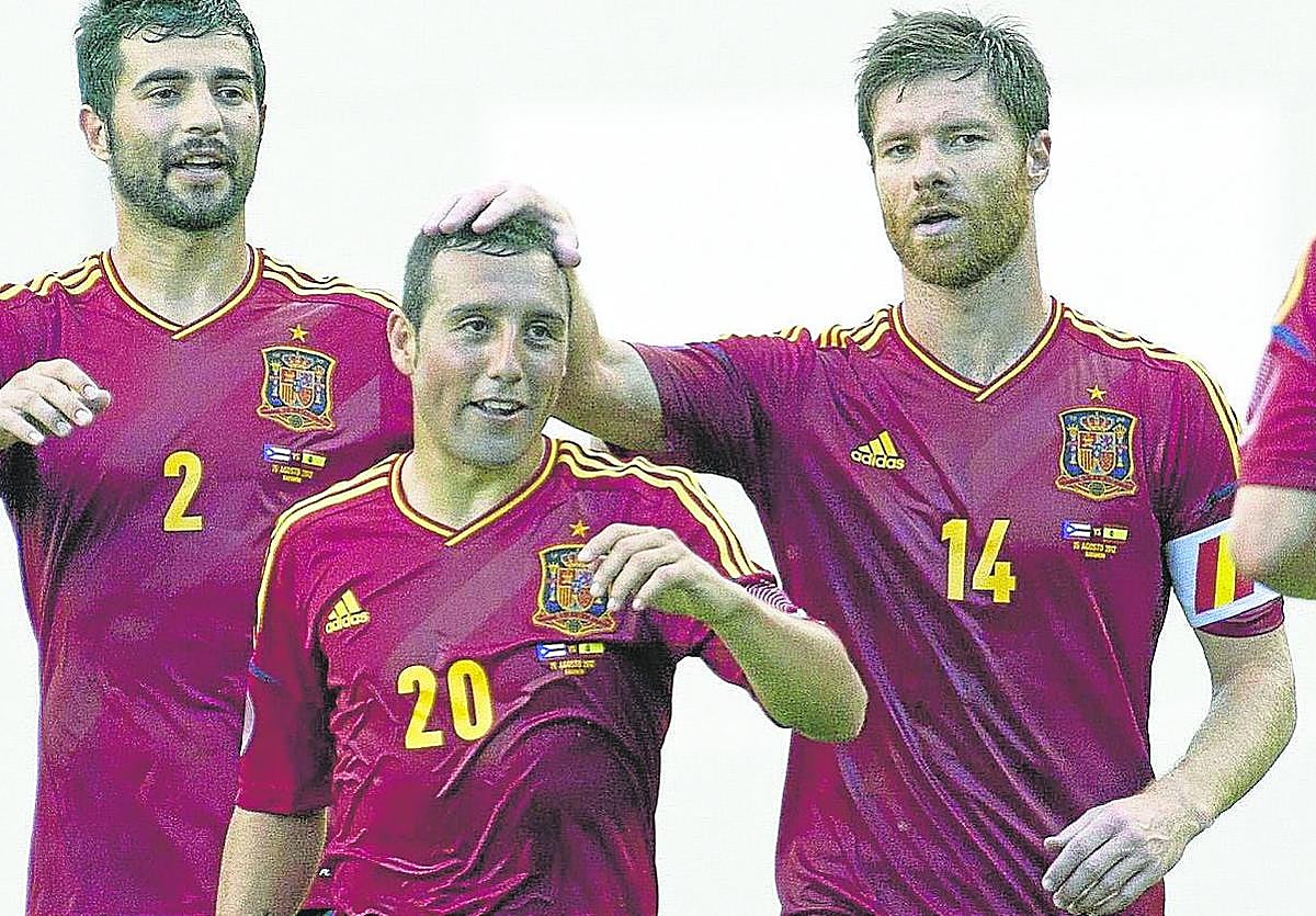 Xabi Alonso toca la cabeza de Santi Cazorla después de que el asturiano marcara un gol con la selección en 2012.