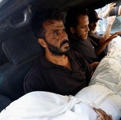 Varios hombres cargan el cuerpo de un gazatí muerto en un incendio provocado por Israel.