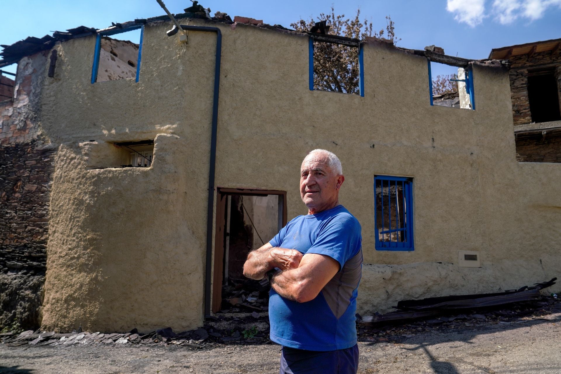 Ramiro Folla enfrente de unas de las casas quemadas del pueblo.