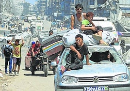 Palestinos huyen de un lugar a otro de Ciudad de Gaza cargados con sus enseres.