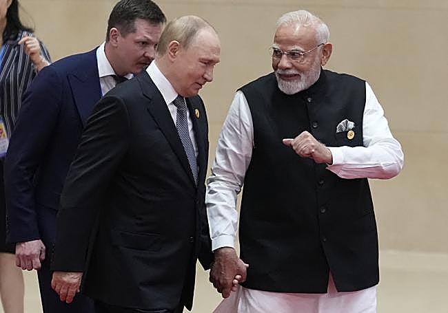 Putin y Modi caminan cogidos de la mano.