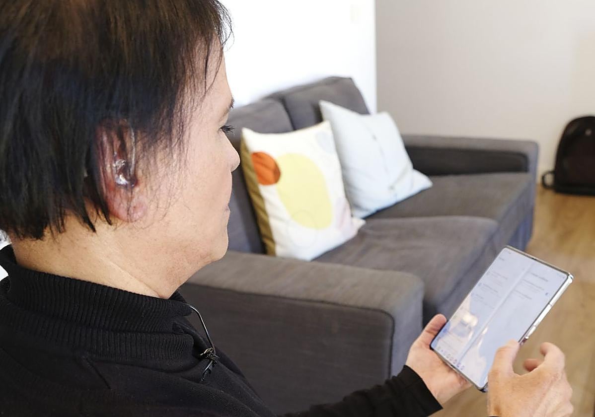 Una mujer con discapacidad auditiva utiliza las funciones de accesibilidad de un móvil de Samsung.