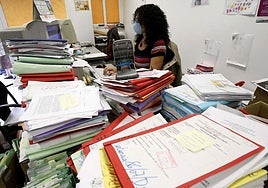 Una funcionaria, rodeada de papeles.