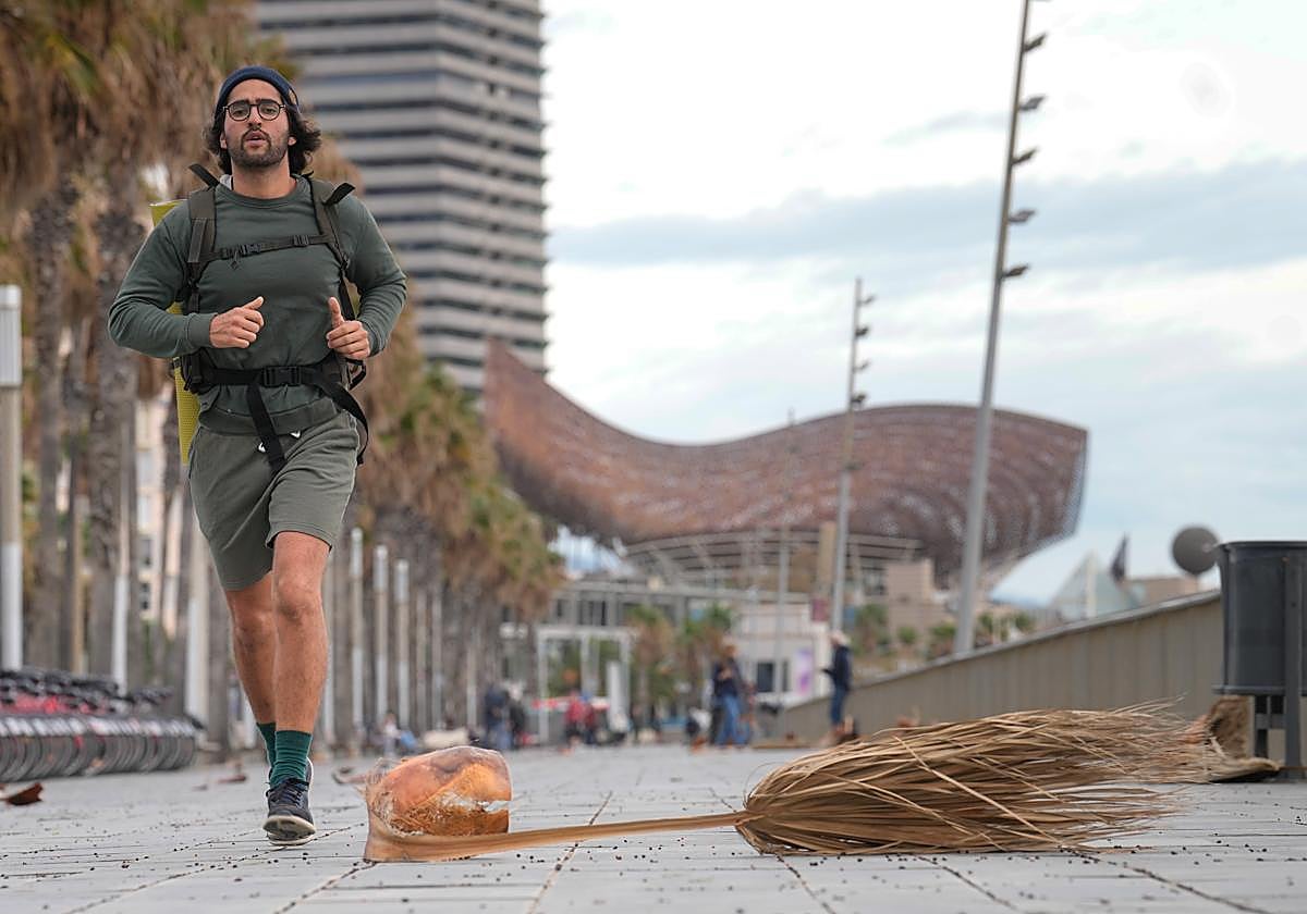 Un joven hace deporte en la Barceloneta con fuertes rachas de viento.