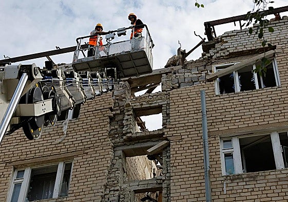 Dos operarios ucranianos trabajan en un edificio bombardeado por Rusia en la región de Donetsk.