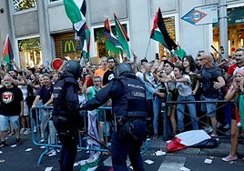 Policías intentan frenar a los manifestantes.