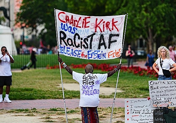 Un hombre sostiene una pancarta contra Kirk en Washington.