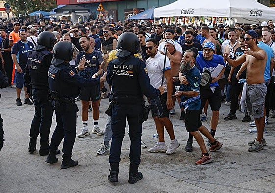 Agentes de la Policía Nacional tratan de contener a aficionados del Olympique de Marsella a su llegada al estadio Santiago Bernabéu.