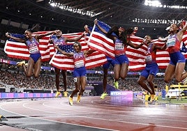 Los dos equipos de Estados unidos del 4x100 celebran la victoria.