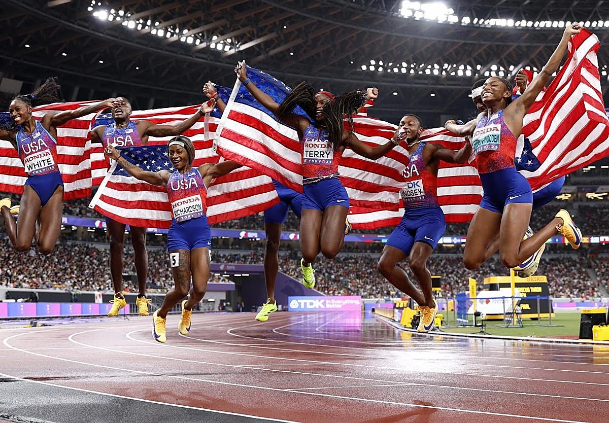Los dos equipos de Estados unidos del 4x100 celebran la victoria.