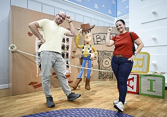 Una pareja posa con el personaje de Toy Story, Woody.