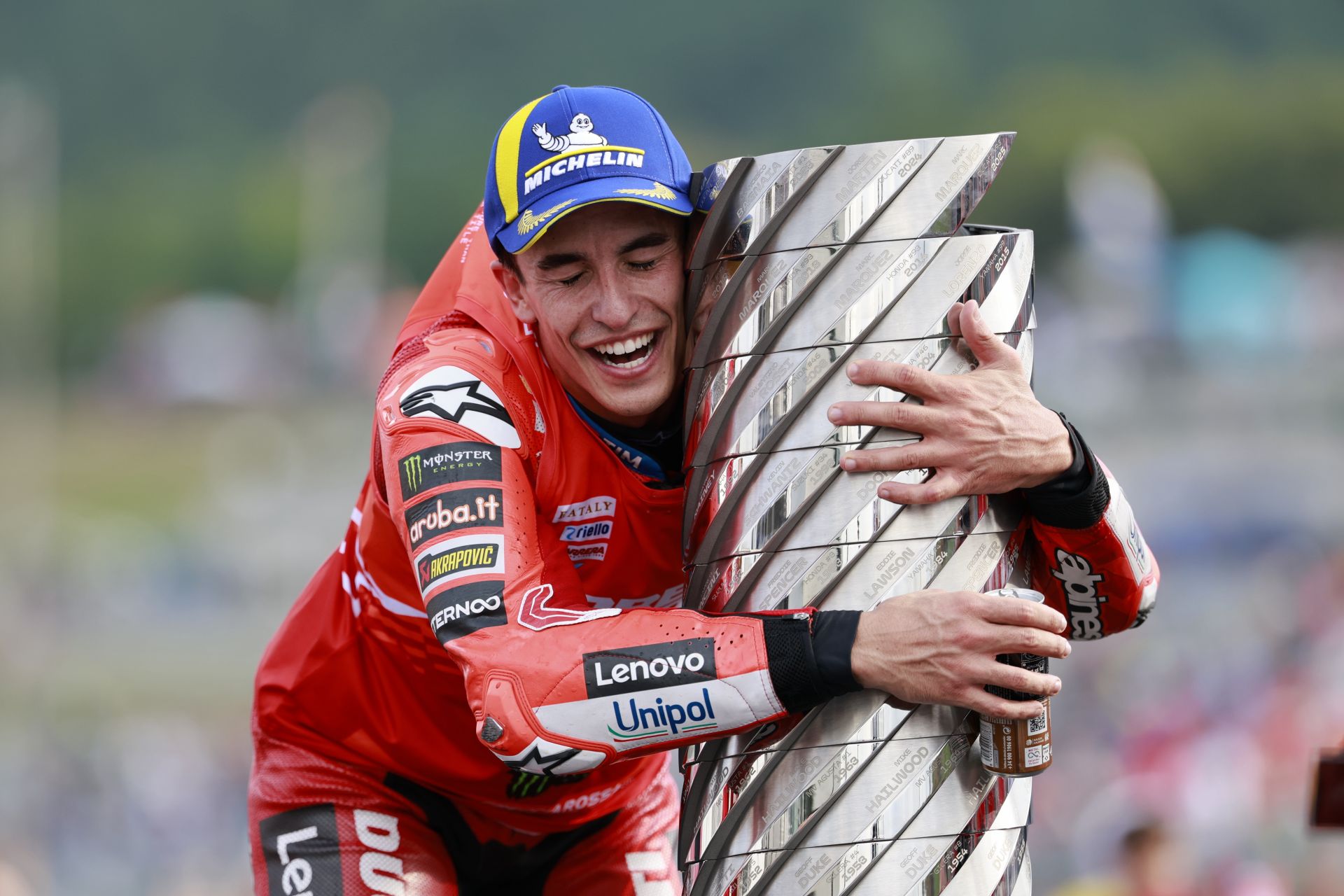 Marc Márquez abraza la renovada Torre de los Campeones, el icónico trofeo de MotoGP, tras proclamarse campeón del mundo en Japón.