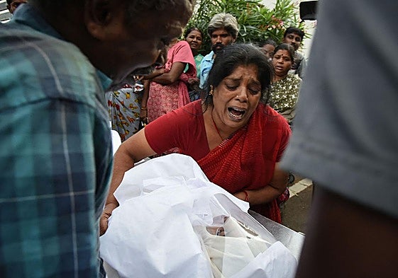Una mujer sostiene el cuerpo de un familiar fallecido en la avalancha.