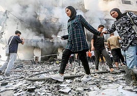 Gazatíes frente a un edificio atacado por Israel.