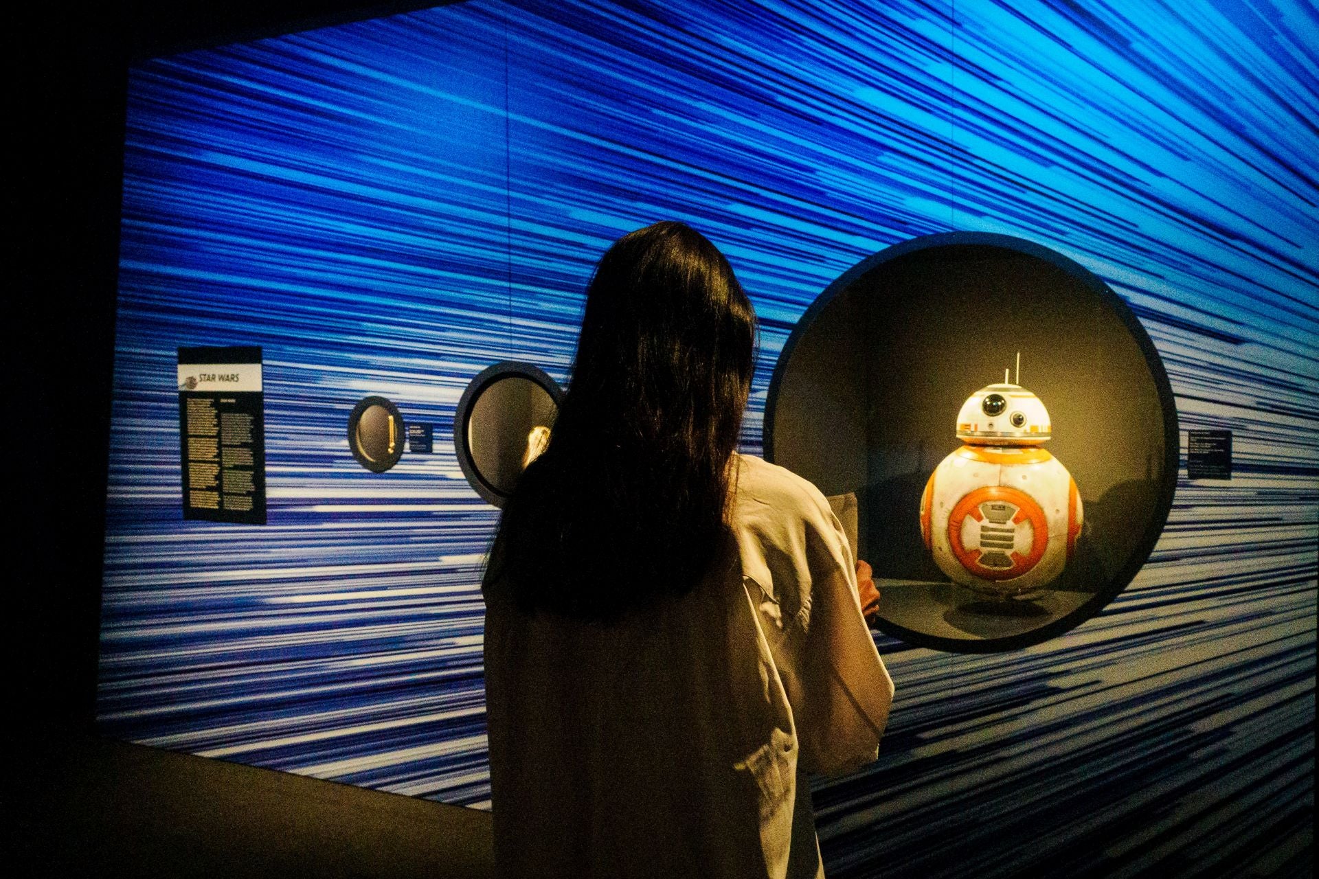 Una joven observa la marioneta del androide BB-8 utilizada en 'Star Wars: El despertar de la fuerza' y en las secuelas posteriores.
