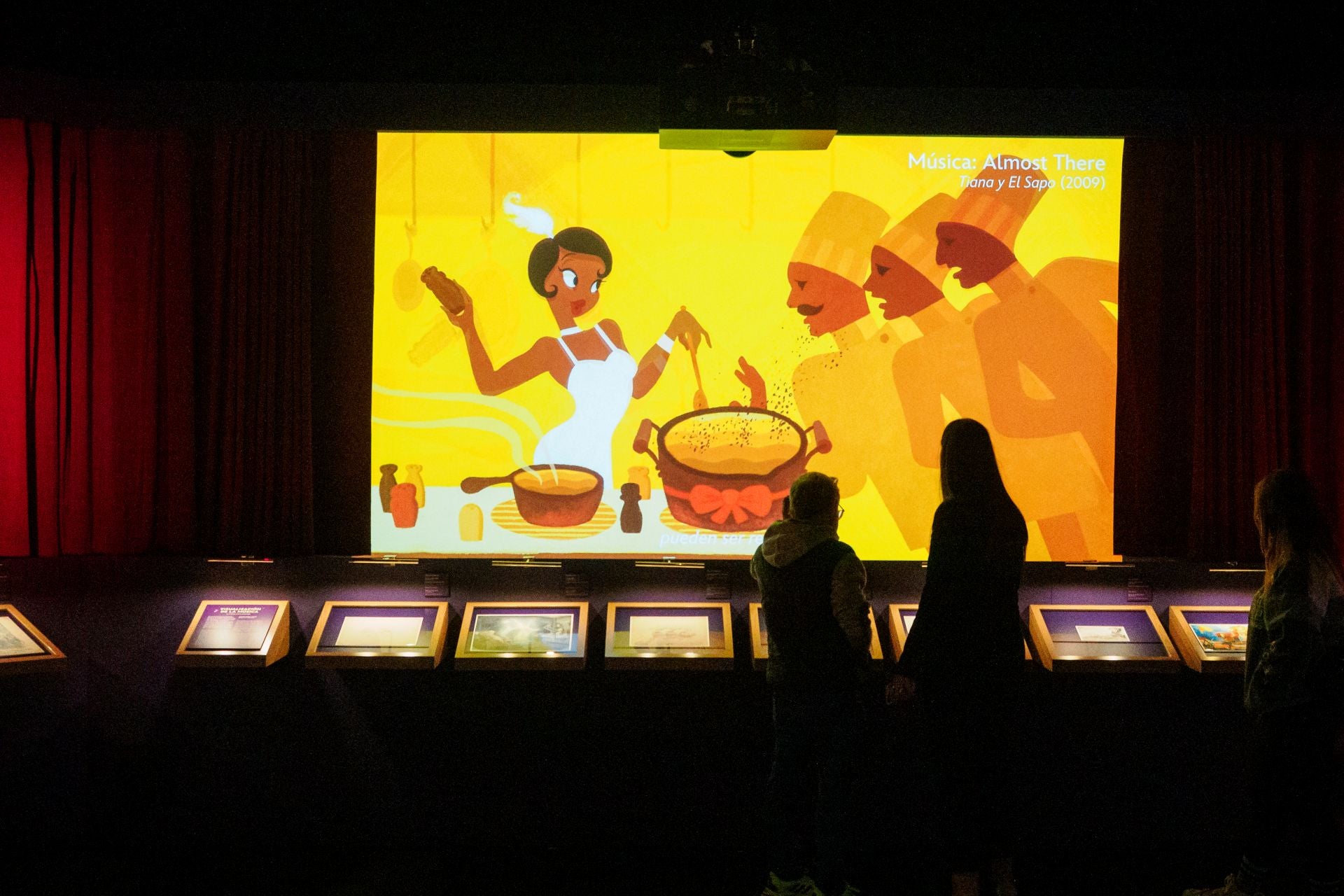 Una gran pantalla pasa algunas de las secuencias musicales más emblemáticas del universo Disney.