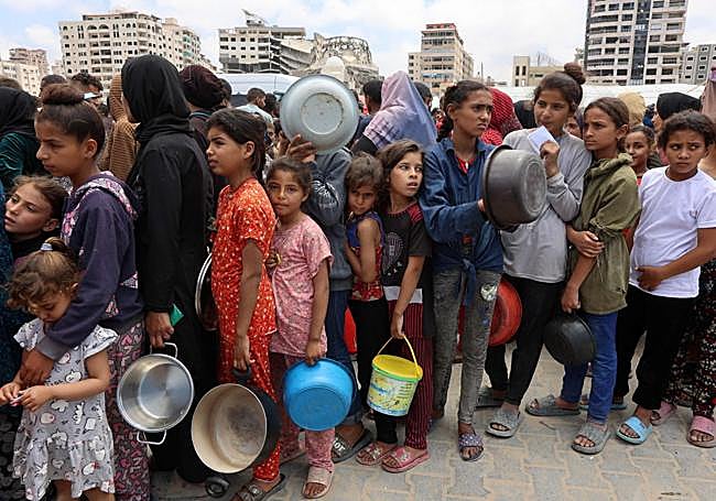 Decenas de personas hacen cola para recoger algo de comida en la Franja.