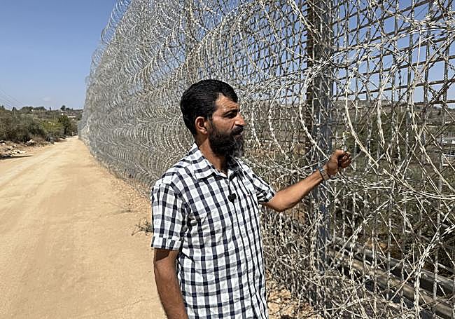 Ayed Ghiifari mira tras la verja instalada por los israelíes que rodea la localidad de Sinjil.
