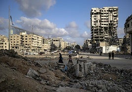 Varias personas caminan entre los escombros de Ciudad de Gaza.
