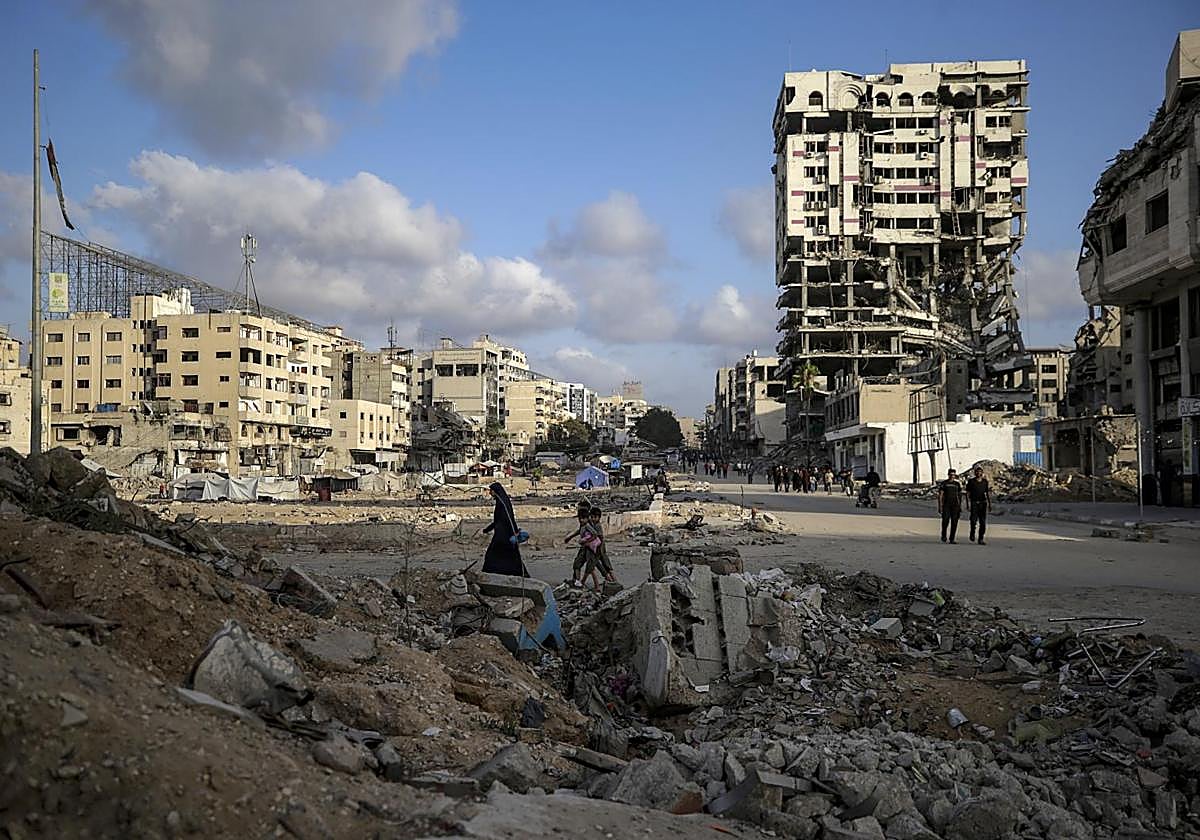 Varias personas caminan entre los escombros de Ciudad de Gaza.