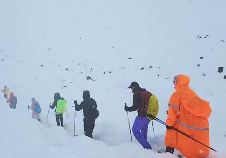 Imagen de un grupo de excursionistas abandonando su campamento en medio de la nieve.