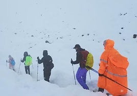 Imagen de un grupo de excursionistas abandonando su campamento en medio de la nieve.