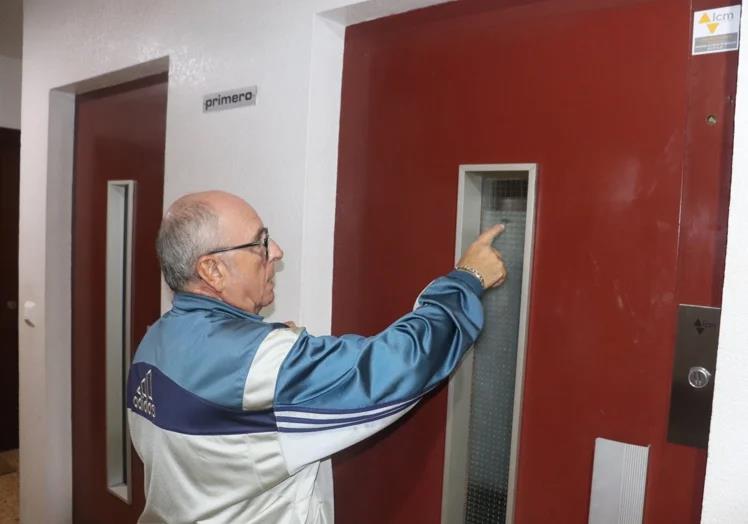 Un vecino de la finca señala el punto en el que se ha quedado parado el ascensor entre la segunda y la primera planta.