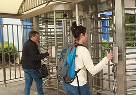 Dos trabajadores fichan al entrar a su empresa.