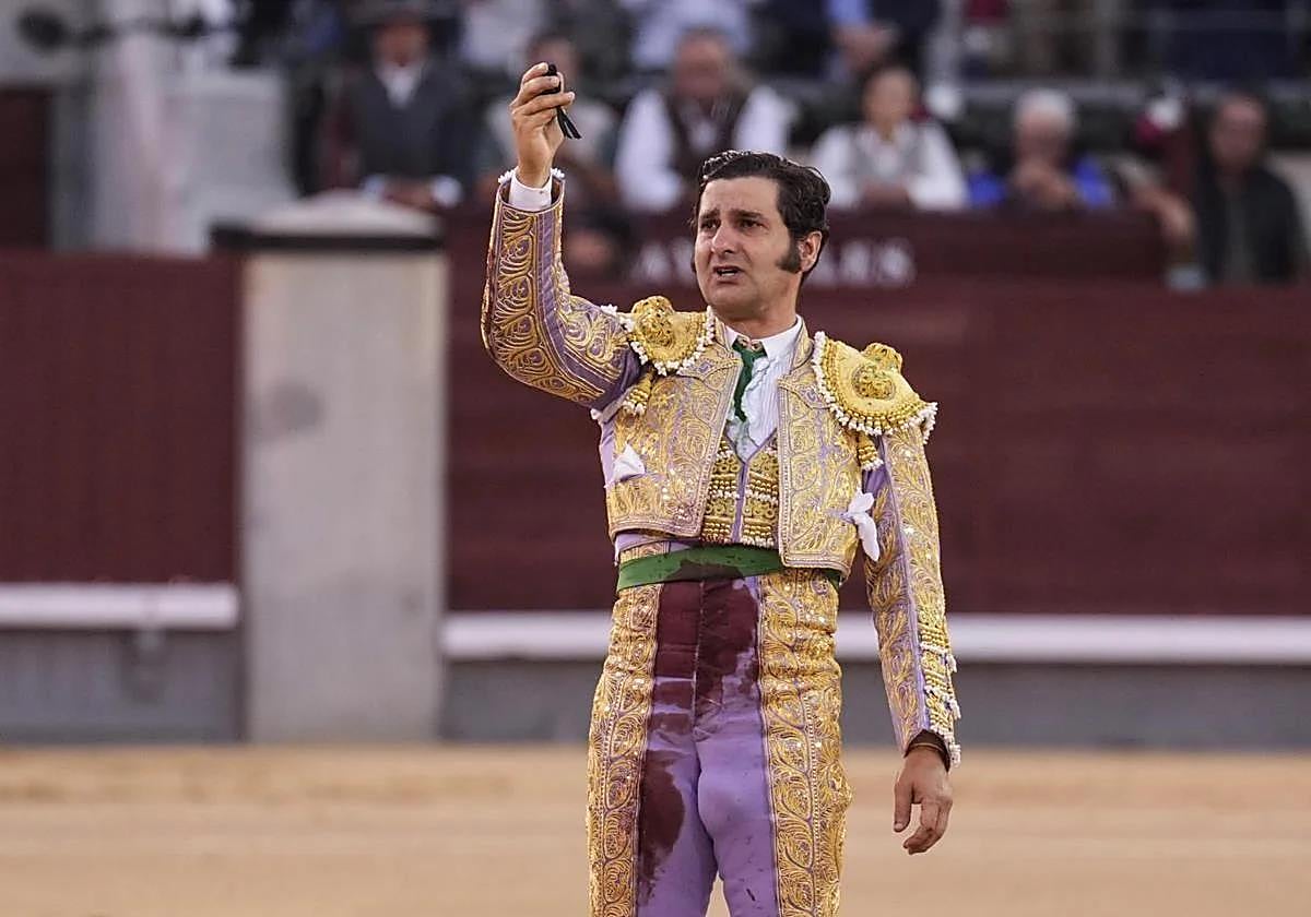 Morante de la Puebla, emocionado, se despide en el centro del ruedo de Las Ventas con la coleta en la mano.