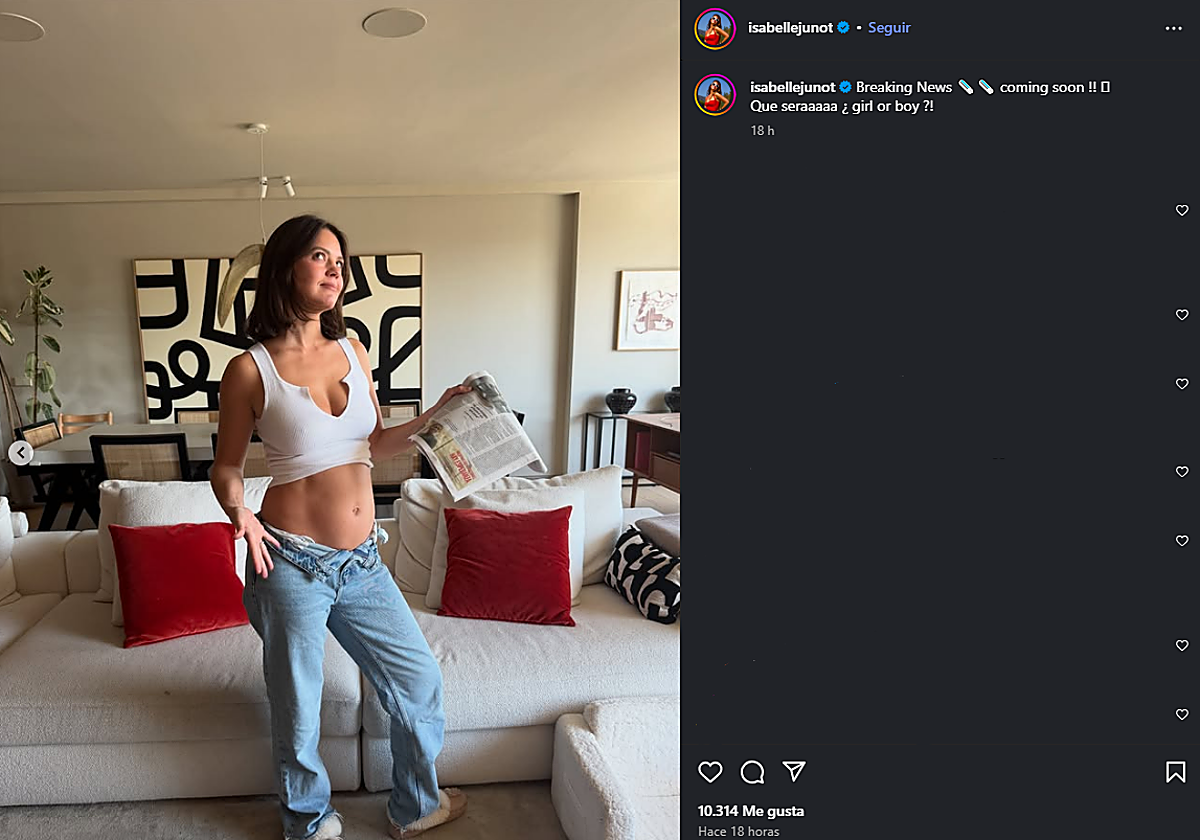 Isabelle Junot poses with a newspaper announcing her pregnancy.