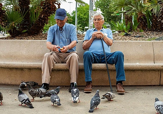Dos jubilados sentados en un banco.