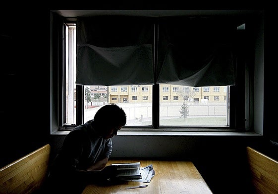 Un chico estudia en la sala de lectura de un centro español de protección de menores.