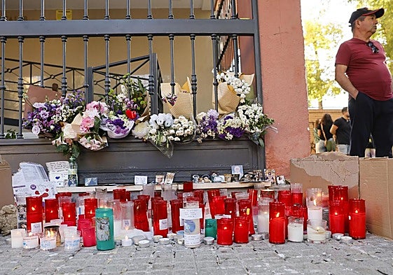 Un pequeño altar improvisado ante la vivienda de Sandra, la joven que se suicidó el pasado martes en Sevilla.
