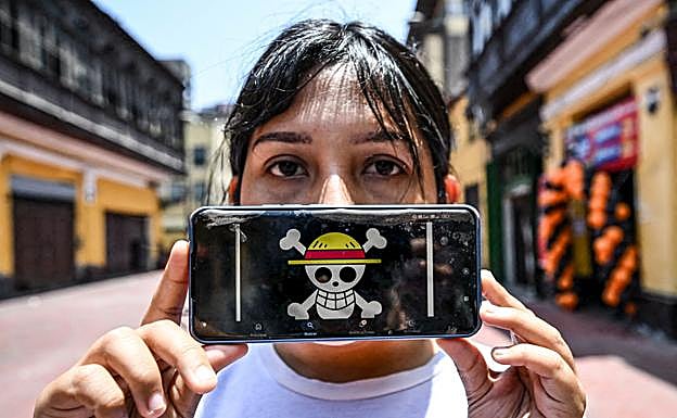 Una joven peruana muestra en su móvil la bandera del manga OnePiece, que exige reformas profundas.