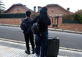 Una de las mujeres afectadas por el desahucio observa la casa junto a su hijo menor de edad.