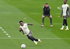Vinicius resbala bajo la mirada de Xabi Alonso durante el entrenamiento de este viernes.