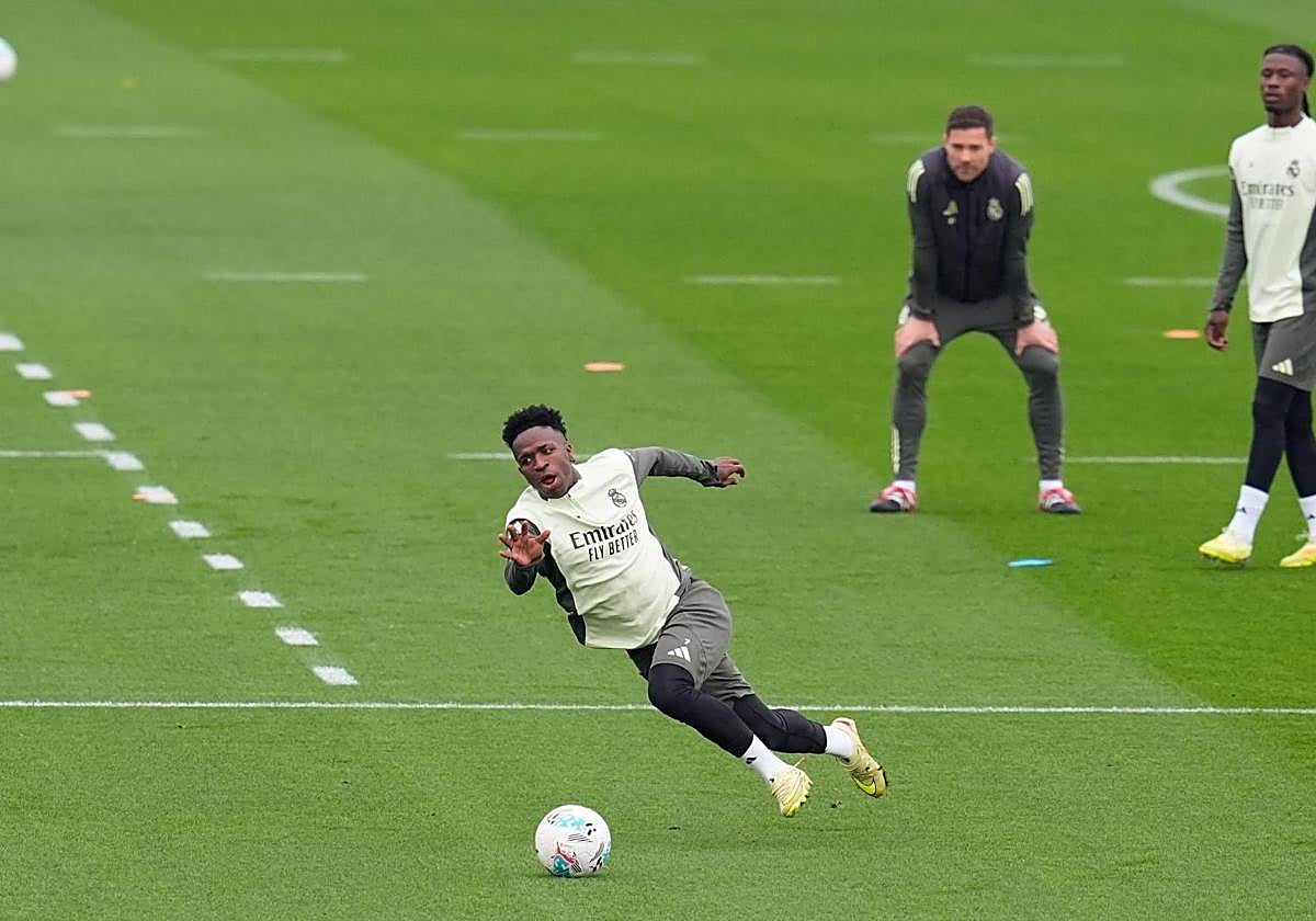 Vinicius resbala bajo la mirada de Xabi Alonso durante el entrenamiento de este viernes.