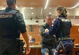 Una ertzainza quita las esposas a este procesado en el juicio celebrado en la Audiencia Provincial hace ahora un año.