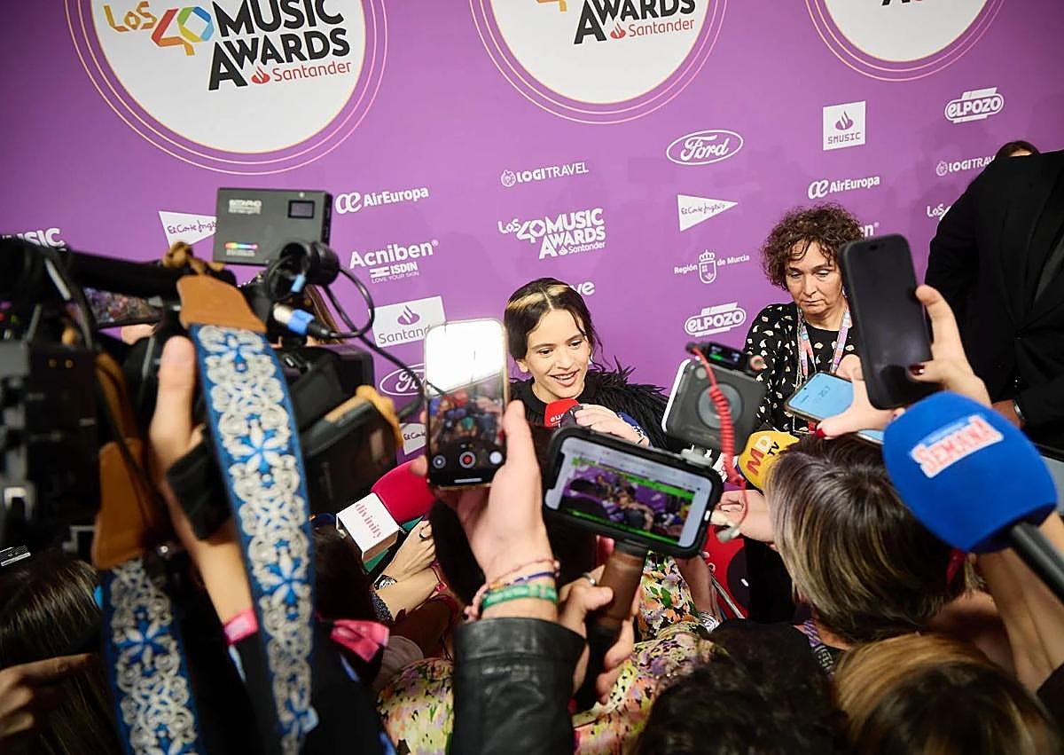 Imagen secundaria 1 - Expectación de Rosalía a su llegada, atendiendo a los medios de comunicación.