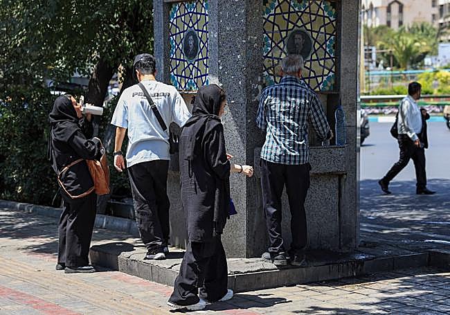 Residentes se abastecen en una fuente pública de Teherán.