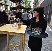 Una camarera sirviendo en una terraza.