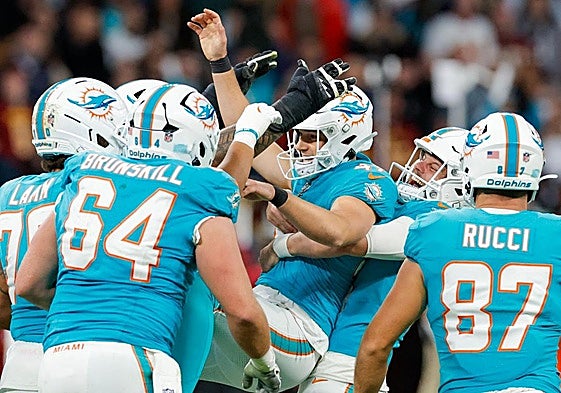 Los jugadores de los Dolphins celebran con patterson la victoria.