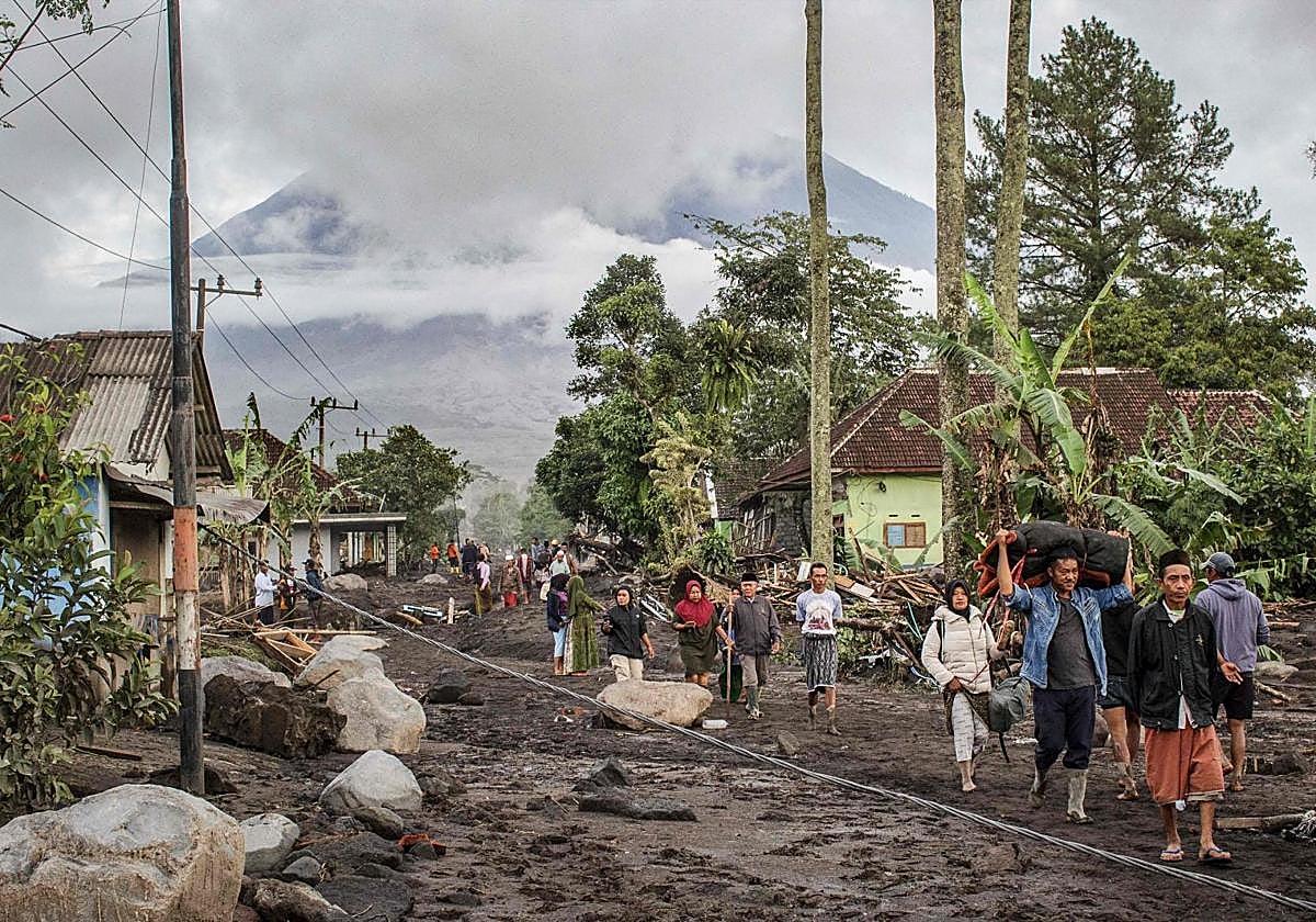Residentes locales se trasladan a lugares seguros tras la erupción del volcán Semeru.