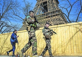 Miembros del ejército francés patrullan bajo la Torre Eiffel.