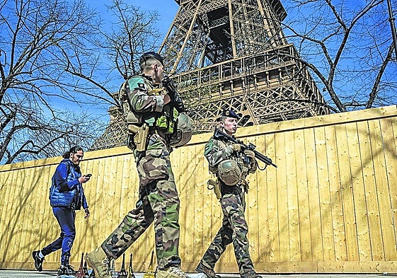 Miembros del ejército francés patrullan bajo la Torre Eiffel.